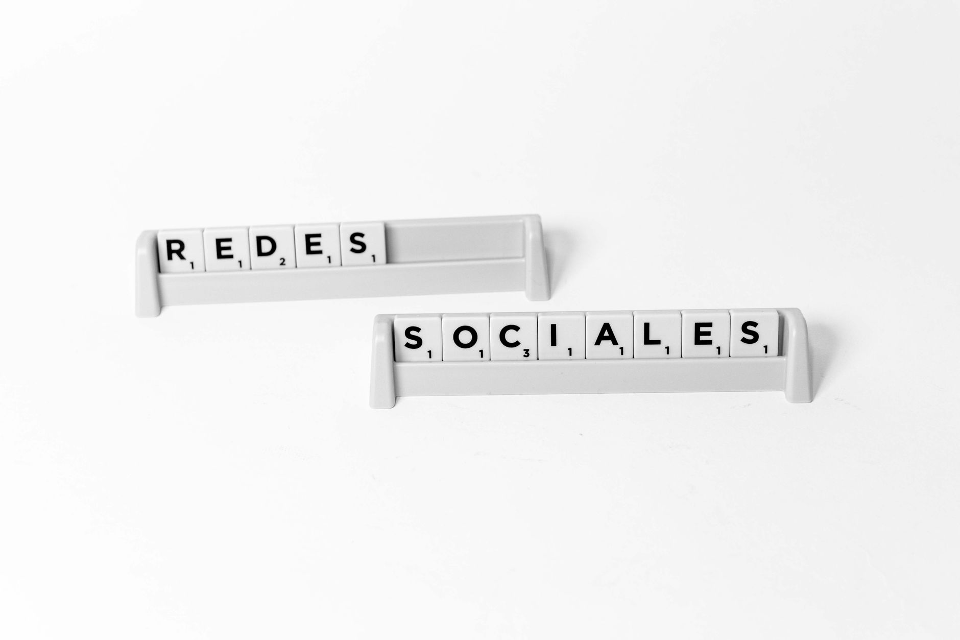 Scrabble tiles arranged to spell 'Redes Sociales', depicting social media on a white background.