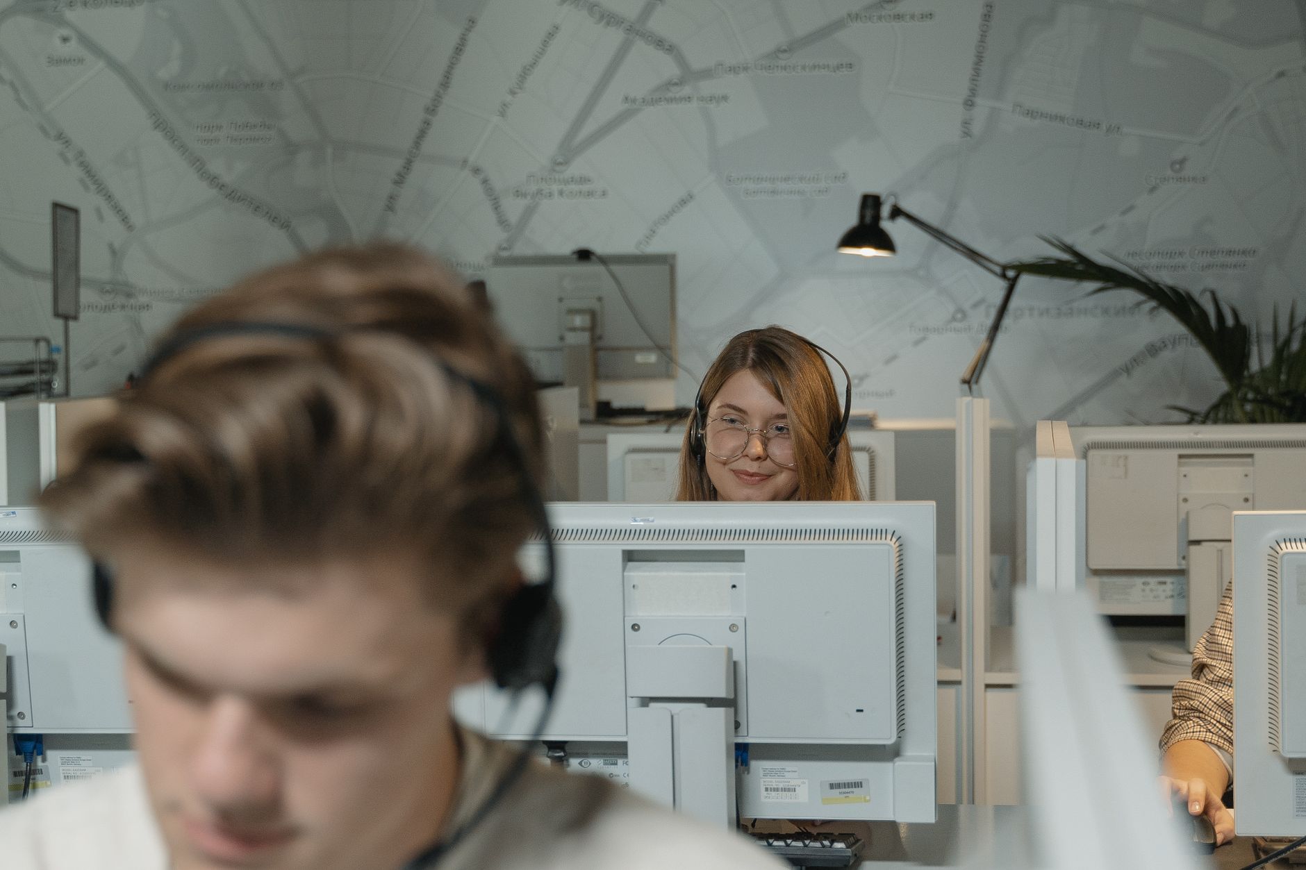 Call center employees working with computers and headsets, providing customer support.