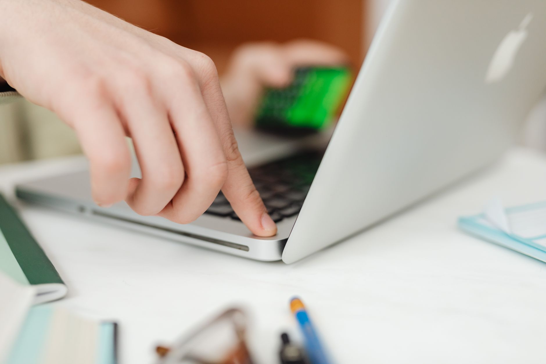 Close-up view of hands operating a laptop while holding a credit card, showcasing online shopping or work.