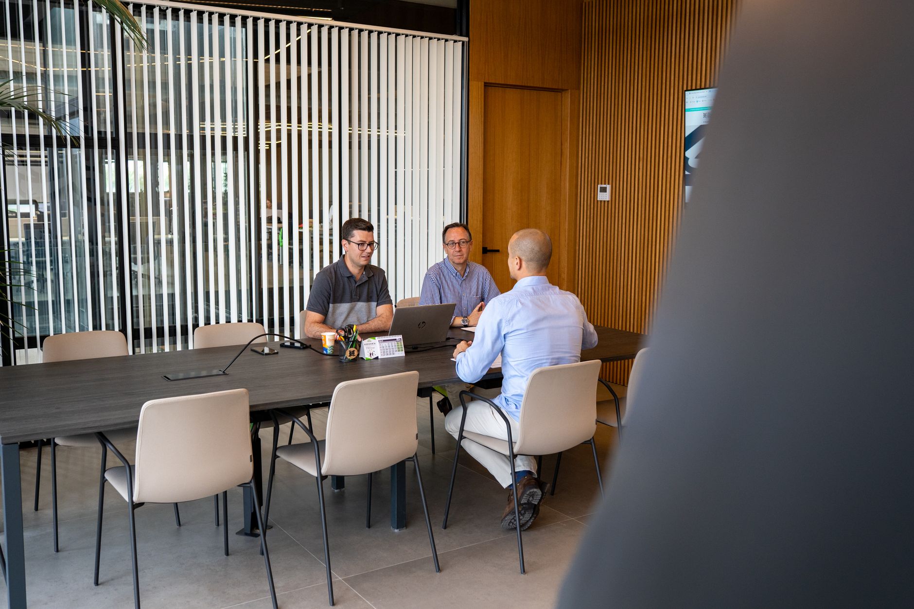 A professional business meeting takes place in a modern Valencia office setting, promoting collaboration and strategy.